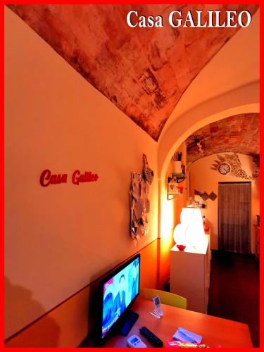 a room with a desk with a computer on a wall at Casa GALILEO- Antiche Dimore Pisane in Pisa