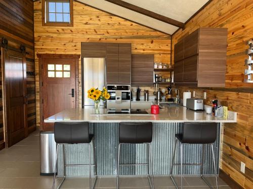 a kitchen with a large island with bar stools at New Cabin with Spectacular Views of Flathead Lake. in Somers