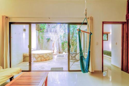 Zimmer mit einer großen Glasschiebetür und einer Badewanne in der Unterkunft Stay in the Heart of Tulum l best location in Town in Tulum