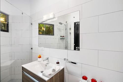 a white bathroom with a sink and a mirror at Peaceful Garden Villa in Sardinal