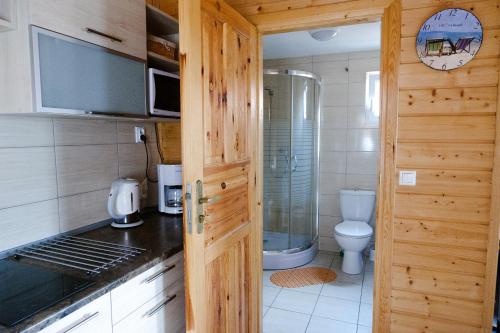 a small bathroom with a toilet and a door at Domki Rejs in Dębki