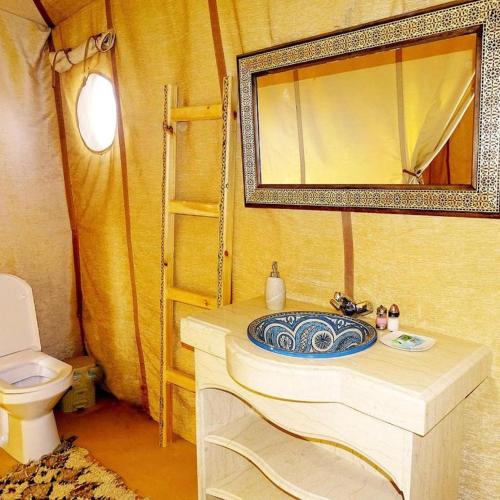 a bathroom with a sink and a toilet at Luxury Desert Camp Merzouga in Merzouga