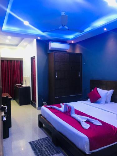 a bedroom with a large bed with a blue ceiling at Coorg ASHOK PALACE in Madikeri