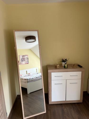a mirror in a room with a bed and a dresser at Roma Apartment in Sandanski