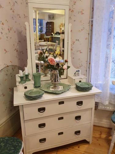 a dresser with a mirror and plates on it at Sofielund Vandrarhem & Camping in Sala