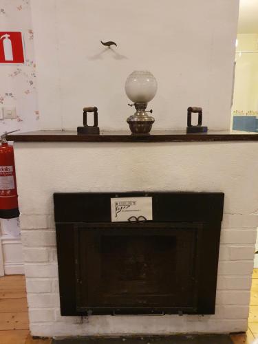 a fireplace with a clock on top of it at Sofielund Vandrarhem & Camping in Sala