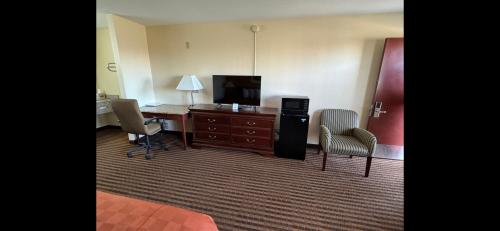 a hotel room with a desk and a computer and chairs at Scottish Inn & Suites - Eau Claire in Eau Claire