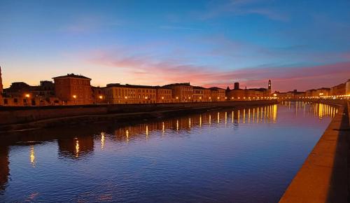 een rivier in een stad 's nachts met gebouwen bij Antiche Dimore Pisane in Pisa