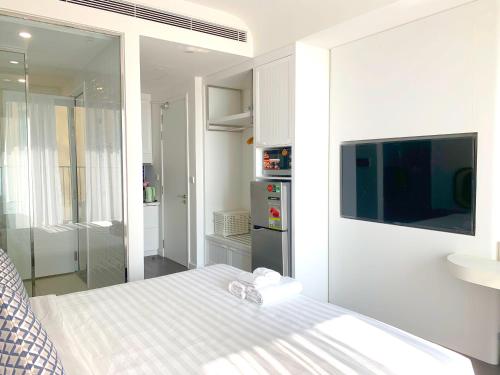 una camera bianca con letto e televisore di P.H.O Apartment a Phu Quoc