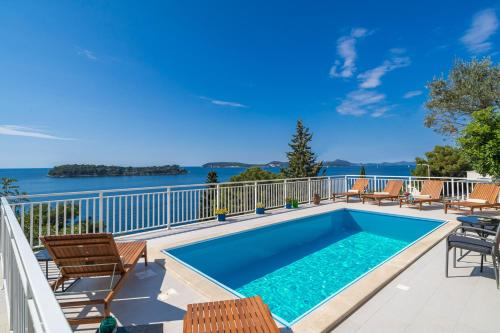 a swimming pool on the balcony of a house with chairs at Villa Green Sunset in Dubrovnik