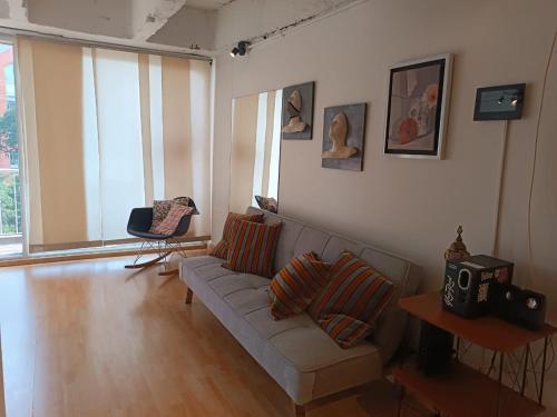 ein Wohnzimmer mit einem Sofa und einigen Fenstern in der Unterkunft Apartamento con balcón Javeriana in Bogotá