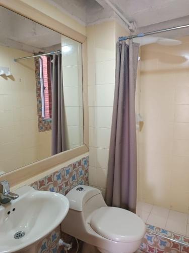 y baño con aseo blanco y lavamanos. en Apartamento con balcón Javeriana, en Bogotá