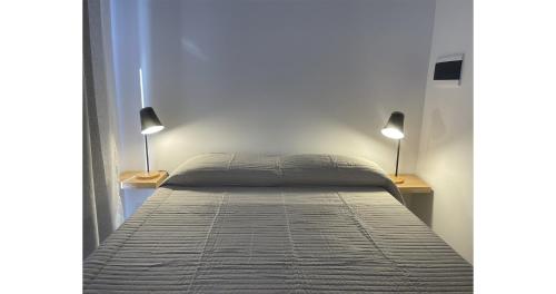 ein Bett in einem Schlafzimmer mit zwei Lampen an zwei Tischen in der Unterkunft Cazon Containers - Módulo Pájaro Carpintero in Saladillo