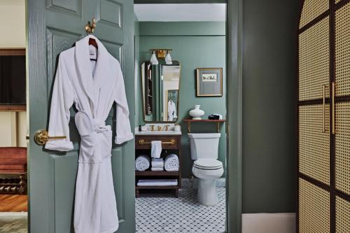 ein Badezimmer mit einem weißen Bademantel, der an einer Tür hängt in der Unterkunft Hotel Granada in Atlanta