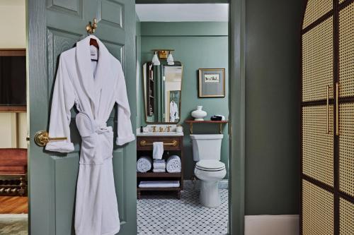 a bathroom with a white robe hanging on a door at Hotel Granada, a Design Hotel in Atlanta