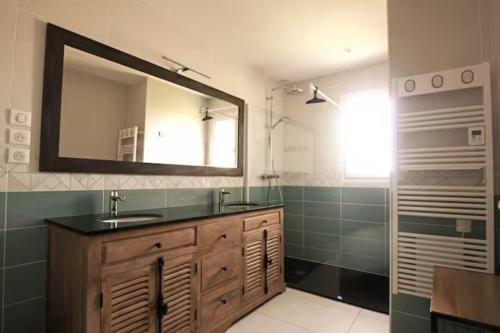une salle de bain avec un lavabo, un miroir et une douche dans l'établissement Maison landaise contemporaine, à Andernos-les-Bains