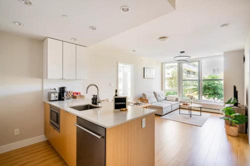 una cucina e un soggiorno con lavandino e piano cottura di Family Size Luxury Residence near BC Place Stadium a Vancouver