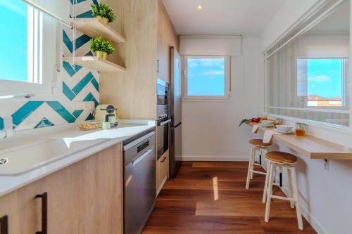 a kitchen with a sink and a counter with stools at CASA TITINA in San Miguel de Abona