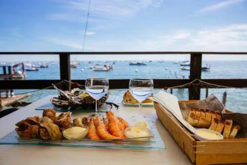 - une table avec deux verres de vin et de nourriture dans l'établissement Maison landaise contemporaine, à Andernos-les-Bains