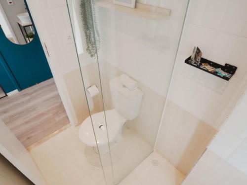 a bathroom with a toilet and a glass shower at Apê Paulista Bela Cintra in Sao Paulo