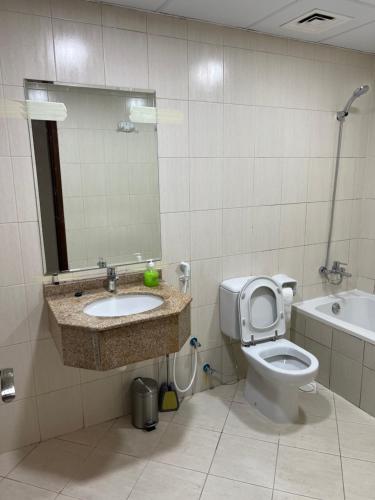 a bathroom with a toilet and a sink and a mirror at F30,R3,Sunrise on the beach,1room inside 3bedroom apartment,(separate washroom outside) in Ajman 