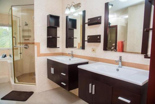 a bathroom with two sinks and a shower at MARIBELLA@CRYSTAL COVE OCHO RIOS in Stanmore Grove