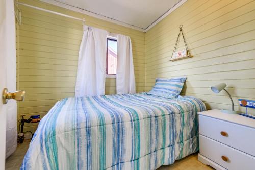 1 dormitorio con cama y ventana en Sunset Bay Cottage with Fire Pit Walk to Beach!, 