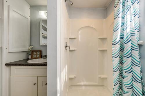 y baño con lavabo y ducha. en Sunset Bay Cottage with Fire Pit Walk to Beach!, 