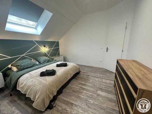 a bedroom with a large bed and a skylight at Gîte Abbecourt, 3 pièces, 4 personnes - FR-1-526-46 in Abbecourt