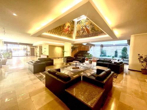 a large living room with couches and a table at Lujosa Habitación - Hotel Akros in Quito