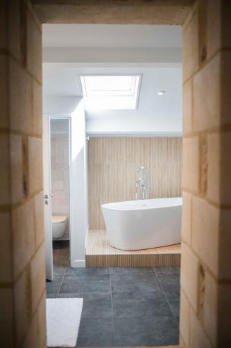 une salle de bain avec une baignoire et un lavabo dans l'établissement Clos de la Barbanne, à Montagne