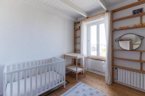 ein Kinderzimmer mit Kinderbett und Fenster in der Unterkunft TY STREJOU - Jolie maison de pêcheur proche port in Ploudalmézeau