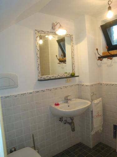 ein Badezimmer mit Waschbecken, Toilette und Spiegel in der Unterkunft Rio Rosa in Bova Marina