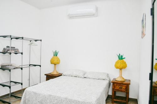 een slaapkamer met een bed en 2 ananas lampen bij La casa Blanca Ticuantepe in Ticuantepe