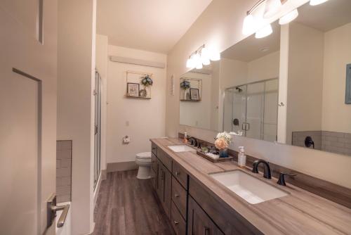 a bathroom with two sinks and a large mirror at Sugar Loaf Haven by KABINO Huge Views Garage Gym Room Fishing Snowmobile in Thayne
