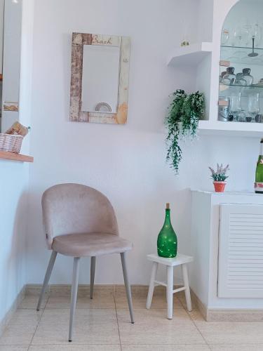 a chair and a vase on a table in a kitchen at Apartamentos Hondahouse Mar Menor, 1 o 2 dormitorios in Cartagena
