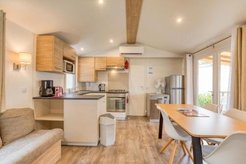 a kitchen and dining room with a table at Mobilhome 530 - 8 personnes in Lattes