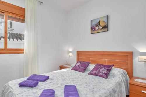 ein Schlafzimmer mit einem großen Bett mit lila Kissen in der Unterkunft Casa Ian in Frigiliana
