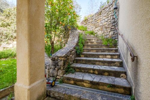 a set of stone stairs next to a stone wall at Appartement Numéro 1 - piscine in Valbonne