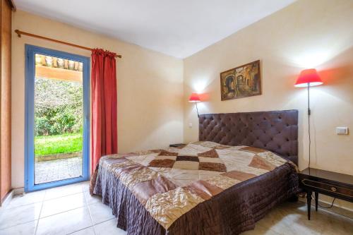 a bedroom with a bed and a large window at Appartement Numéro 1 - piscine in Valbonne