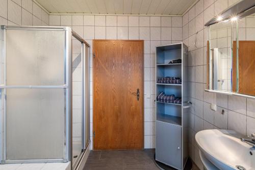 ein Badezimmer mit einer Dusche, einem Waschbecken und einer Glastür in der Unterkunft Haus am Twistesee in Wetterburg