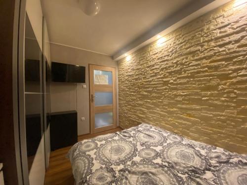 a bedroom with a stone wall and a bed at Apartament morski in Gdynia