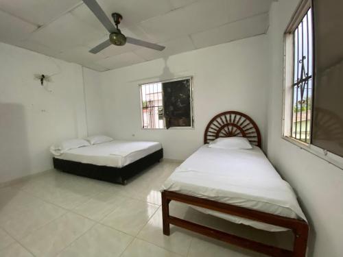a bedroom with two beds and a ceiling fan at Hermoso apartamento amoblado in Mompós