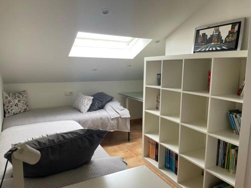 ein Schlafzimmer mit einem Bett und einem Bücherregal in der Unterkunft Villa Charneca, jardín y mar in Vigo