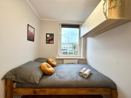 a small bedroom with a bed with a window at MMRent Moonlight Room in Gdańsk