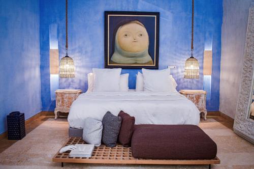 a bedroom with a bed with a portrait of a woman at Hotel Santiago Botero in Cartagena de Indias