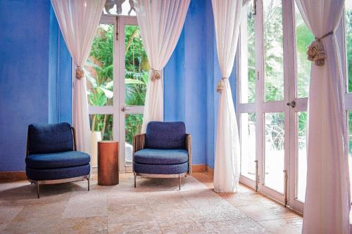two chairs in a room with blue walls and windows at Hotel Santiago Botero in Cartagena de Indias