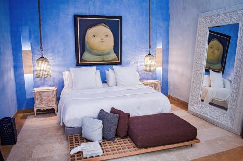 a bedroom with a bed and a portrait of a baby at Hotel Santiago Botero in Cartagena de Indias