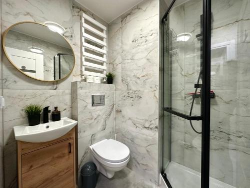 La salle de bains est pourvue d'une douche, de toilettes et d'un lavabo. dans l'établissement MMRent Moonlight Room, à Gdańsk