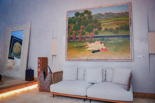 a living room with a couch and a painting on the wall at Hotel Santiago Botero in Cartagena de Indias